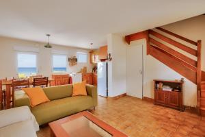 a living room with a couch and a kitchen at Vues mer - Accès direct plage - 4 adultes 3 enfants in Erquy