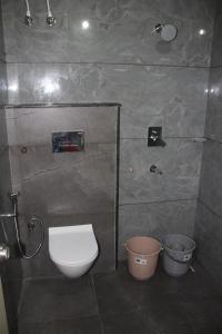 a bathroom with a white toilet and two buckets at COORG WINDYSIDE HOMESTAY With Campfire PAID in Madikeri +11 photos