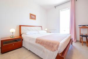 a bedroom with a large bed and a window at Villa Medea in Casarano +16 photos