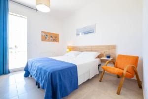 a white bedroom with a bed and a chair at Villa Medea in Casarano