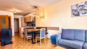 a living room with a table and a blue couch at Apartments Bergblick in Sonnenalpe Nassfeld