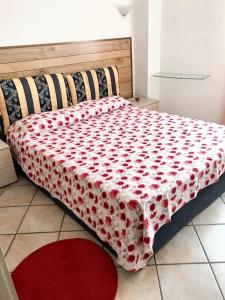 ein Bett mit einer roten und weißen Decke drauf in der Unterkunft 2 bedrooms house at Badalucco 8 km away from the beach in Badalucco