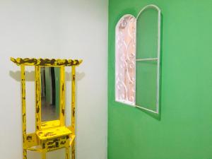 una parete verde con specchio e scala gialla di hospedagem Manaká proximo ao Centro vista incrível a Cunha