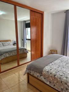 1 dormitorio con cama y espejo grande en BKD1 - Apartamento entero a 50 metros PLAYA DE LAS CANTERAS, en Las Palmas de Gran Canaria