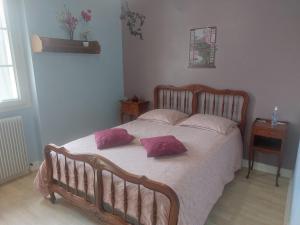 a bedroom with a bed with two pillows on it at LES ROSSIGNOLS in Saint-Martin-sur-Ocre