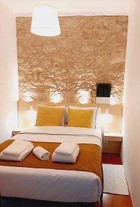 een slaapkamer met een groot bed en handdoeken bij Casal Mala-Posta in Rio Maior