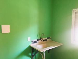 una parete verde con lavandino in bagno di hospedagem Manaká proximo ao Centro vista incrível a Cunha