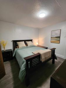 1 dormitorio con 1 cama grande y 1 mesa en Oasis de la Baie en Port-Daniel