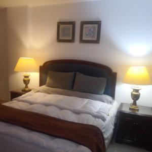 une chambre avec un lit avec deux lampes dessus dans l'établissement The most luxurious, most wonderful location in Egypt, New Cairo, Madinaty Resort, air conditioning, free internet الافخم أروع موقع مصر القاهرة الجديدة منتجع مدينتي مكيفة انترنت مجاني, à Madinaty