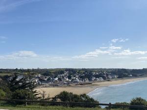 Una vista de una playa con casas y el océano. en 410 - A ERQUY, dans le résidence de CAROUAL, en Erquy