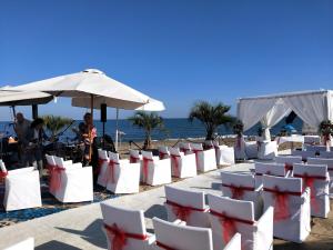 een rij witte stoelen op het strand bij Heron apartments in Lido di Jesolo
