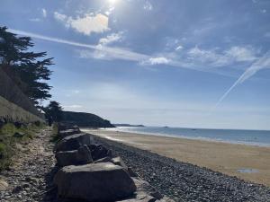una fila de rocas en una playa cerca del océano en 410 - A ERQUY, dans le résidence de CAROUAL, en Erquy 3 fotos más