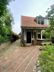 una casa con un patio de ladrillo delante de ella en Tiny House De Oude Berg, en Bergen