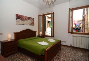 Un dormitorio con una cama verde y una ventana en Classic Venice House, en Venecia