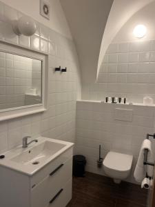 a white bathroom with a sink and a toilet at Penzion Kaplanka in Znojmo
