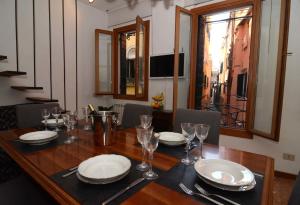 una mesa de comedor con platos y vasos. en Classic Venice House, en Venecia