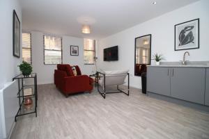 a living room with a red chair and a sink at Modern Two BR | Free Parking in Taunton +48 photos