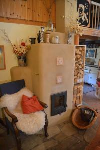 ein Wohnzimmer mit einem Kamin und einem Stuhl in der Unterkunft Rotes Kreativ-Ferienhaus in Bad Lausick