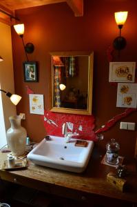 a bathroom with a sink and a mirror on a counter at Rotes Kreativ-Ferienhaus in Bad Lausick +16 photos