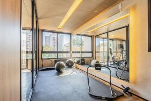 a gym with cardio equipment in a building with windows at Studios modernos e completos ao lado da estação Vila Mariana in Sao Paulo