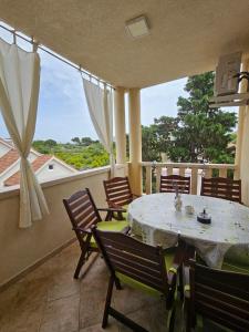 a dining room with a table and chairs on a balcony at Apartment Tena in Novalja