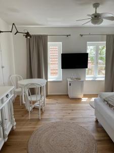 ein weißes Wohnzimmer mit einem Tisch und einem Sofa in der Unterkunft Penzion Kaplanka in Znojmo