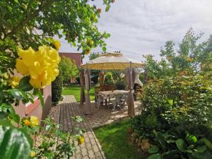 a garden with a table and a gazebo at Landhaus Forrás in Balatonfüred