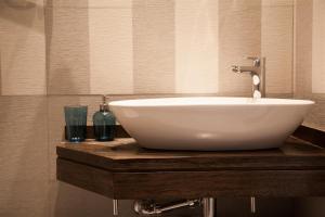 a white bowl sink on a wooden counter in a bathroom at Apartamento City SOLO ADULTOS in Madrid