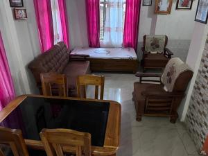 a living room with a couch and chairs and a tv at Happy Homestay Sittong in Mangpu +15 photos