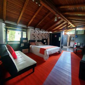 1 dormitorio con cama y sofá en Hosteria Airport Garden en Tababela