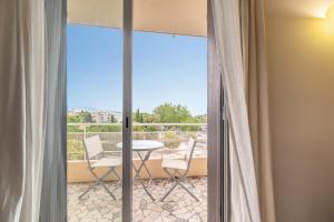 a room with a balcony with a table and chairs at Vue mer, 2 pièces Terrasse, 5 min du centre in Antibes