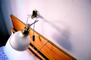 une lampe blanche assise au-dessus d'une commode dans l'établissement Logrocity Puerta del Ebro Parking privado gratis, à Logroño
