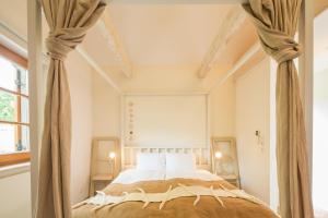 sypialnia z łóżkiem z baldachimem i zasłonami w obiekcie WEINLOFTS Weinloft I w mieście Edlitz im Burgenland