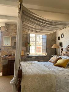 Casa Bohême في Caunes-Minervois: غرفة نوم مع سرير مظلة ونافذة