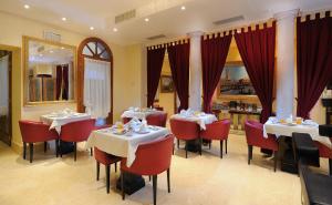 a restaurant with two tables and red chairs at Hotel Ai Due Principi in Venice