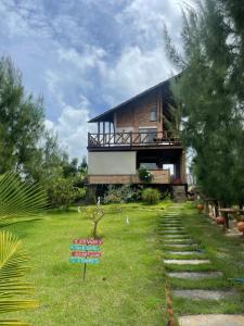 a house with a grassy yard with a house at Chalé MACAPAZ in Luis Correia