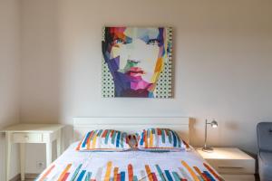 1 dormitorio con 1 cama con una pintura en la pared en Vue mer, 2 pièces Terrasse, 5 min du centre, en Antibes