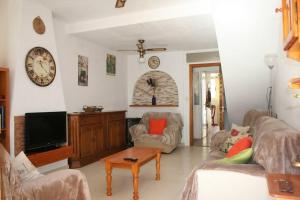 un soggiorno con divano e TV di Casa Samuel El Campello house with communal pool a El Campello