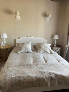 a bed in a bedroom with two tables and two lamps at Gite 'la fée de Montigny sur Aube' in Montigny-sur-Aube