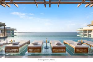 una piscina con sillas y el océano en Mandarin Oriental Jumeira, Dubai en Dubái
