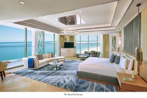 a hotel room with a large bed and a living room at Mandarin Oriental Jumeira, Dubai in Dubai