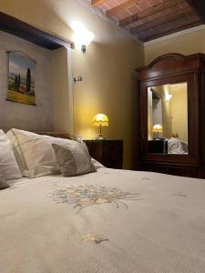een slaapkamer met een groot bed en een spiegel bij Pienzalettings "Suites" in Pienza