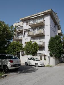 two cars parked in front of a white building at Grace's Home in San Salvo