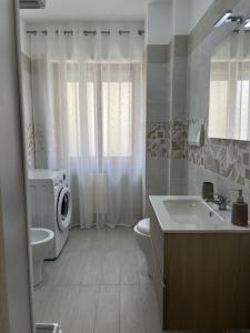 a bathroom with a sink and a washing machine at Grace's Home in San Salvo +11 photos
