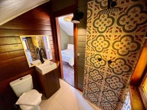 uma casa de banho com um WC, um lavatório e um espelho. em Reserva Santo Antônio em Santo Antônio do Pinhal