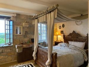 Casa Bohême في Caunes-Minervois: غرفة نوم مع سرير مظلة ونافذة