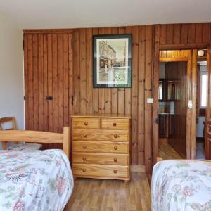 1 dormitorio con 2 camas y vestidor en Le Dy en fleurs en Saint-Maurice-en-Cotentin