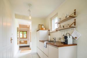 a kitchen with white cabinets and a sink at Weinloft I by WEINLOFTS in Edlitz im Burgenland