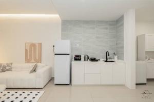 a white kitchen with a white couch and a refrigerator at [Creamy house KSL 2 JB] #6Pax #Austin #18th floor in Johor Bahru +32 photos