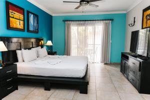 een blauwe slaapkamer met een bed en een televisie bij Hotel Brisa in Punta Cana